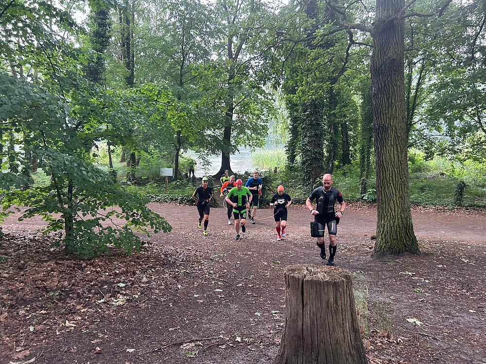 SWIMRUN RHEINSBERG: Trainer Michael in voller Montur vorweg, der Rest folgt schnaufend. © SCC EVENTS / Philip Lehmann