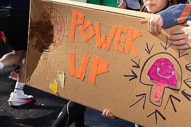 Homemade cardboard sign with the words “Power Up.”