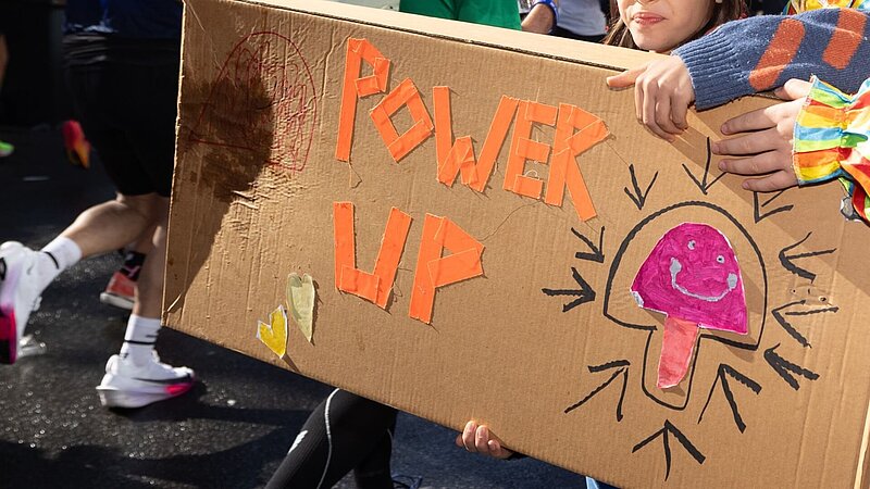 Cardboard sign with the words "Power Up".