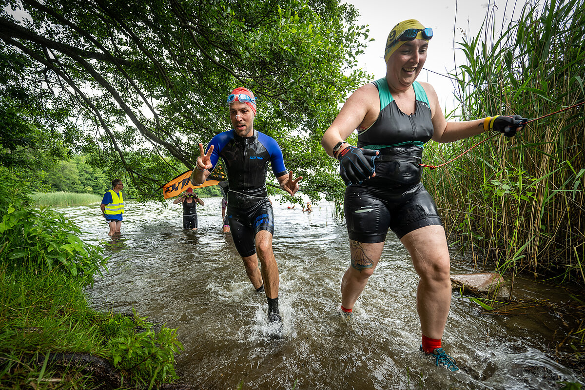 SwimRun 2023: Teilnehmer:innen beim Ausstieg aus dem Wasser auf die Strecke SCC EVENTS / Tilo Wiedensohler