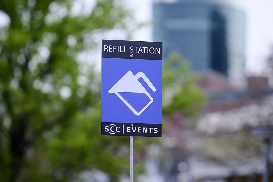 A blue sign with the words ‘REFILL STATION’ and an icon of a water jug.