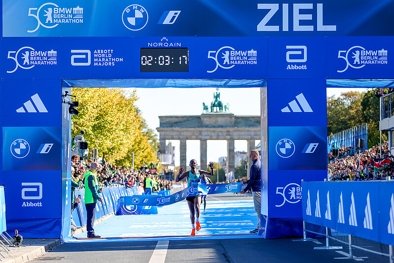 Milkesa Mengesha crosses the finish line of the BMW BERLIN-MARATHON after 02:03:17 with the Brandenburg Gate in the background
