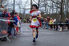 Berlin New Year's Eve Run 2022: Costumed runner passes spectators in the finish lane @ SCC EVENTS / Tilo Wiedensohler