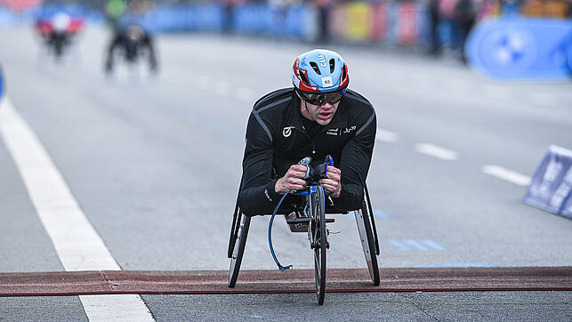 In the racing wheelchair, David Weir crosses the finish line exhausted.