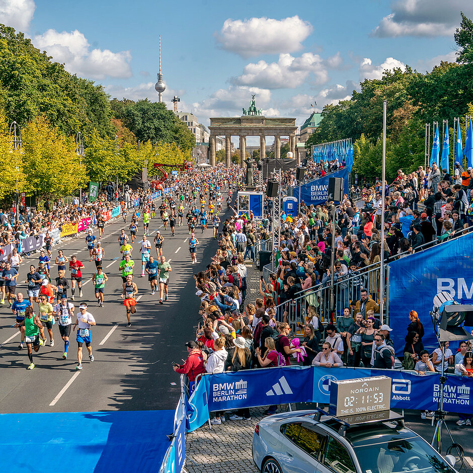 Tribüne neben der Zielgeraden nach dem Brandenburger Tor. Auf der anderen Seite Zuschauende hinter der Streckenbegrenzung.