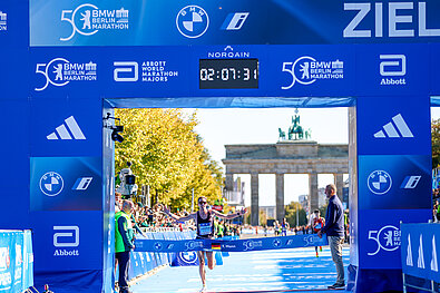 Erster Deutscher Läufer Sebastian Hendel läuft durchs Zieltor des 50. BMW BERLIN-MARATHON. Die Uhr zeigt 02:07:32 an.