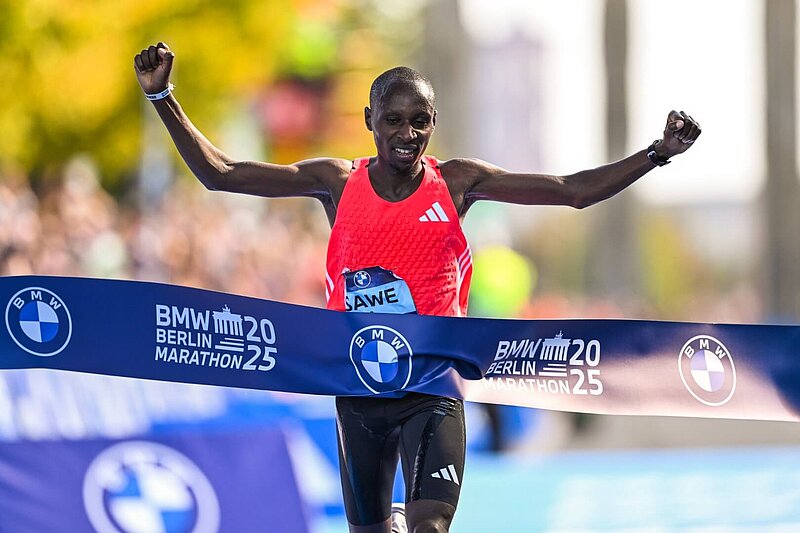 Sabastian Sawe celebrates as he runs across the finishing line.