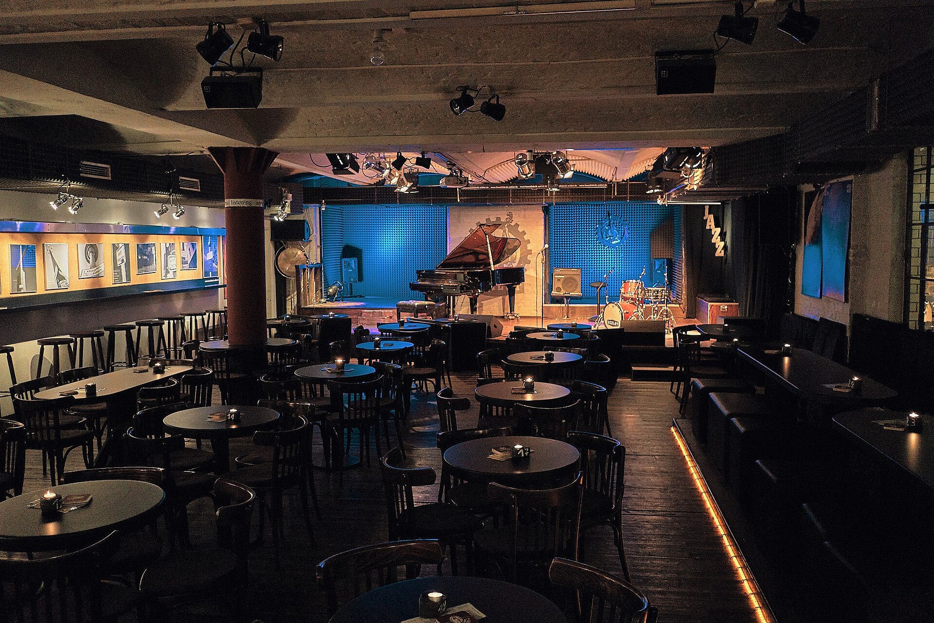 Innenraum der Kunstfabrik Schlot mit Tischen, Stühlen und beleuchteter Jazz-Bühne.