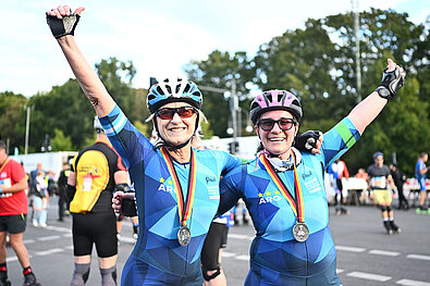 BMW BERLIN-MARATHON Inlineskating 2023: Two women celebrate their medals at the finish line © SCC EVENTS / Marvin Güngor