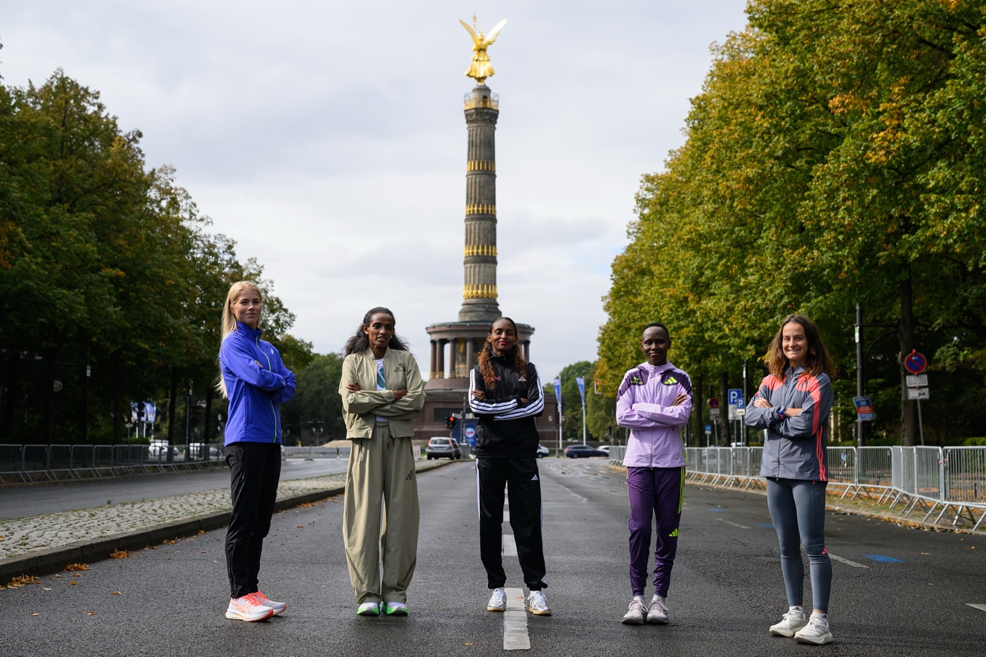 From left to right: Alisa Vainio, Dera Dida, Tigst Assefa, Rosemary Wanjiru, and Manon Trapp pose on Straße des 17. Juni with the Victory Column in the background.
